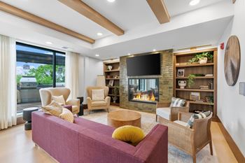 The lounge area and fireplace in the Private Dining Room, a reservable community amenity at Lilia Apartments in Lilydale, MN 55118